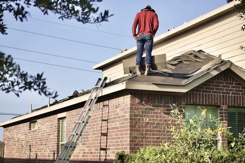 Professional roofer working on a residential roof in Benton